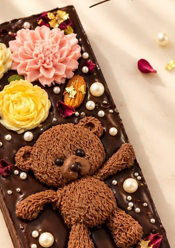 Dark chocolate bar with a sculpted teddy bear and flowers